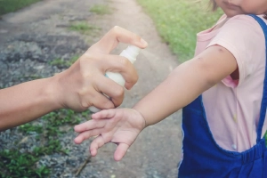 Spray contro le zanzare spruzzato su braccio di un bambino