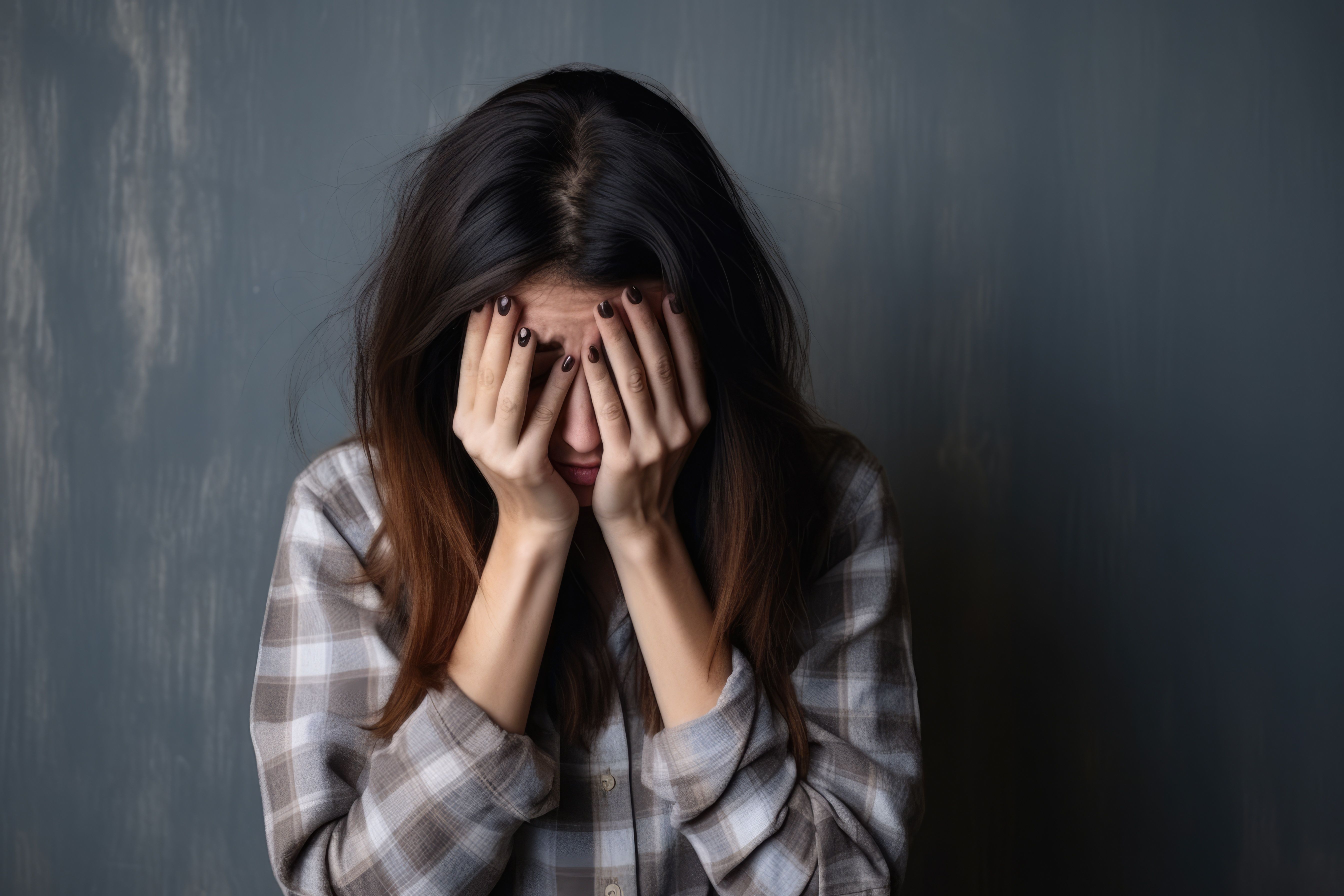 donna con volto tra le mani prova dolore