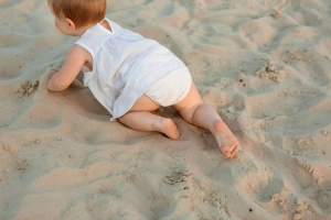 bambino sulla sabbia al tramonto al mare
