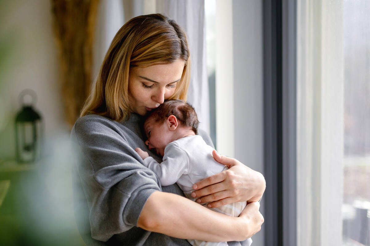una mamma abbraccia un neonato