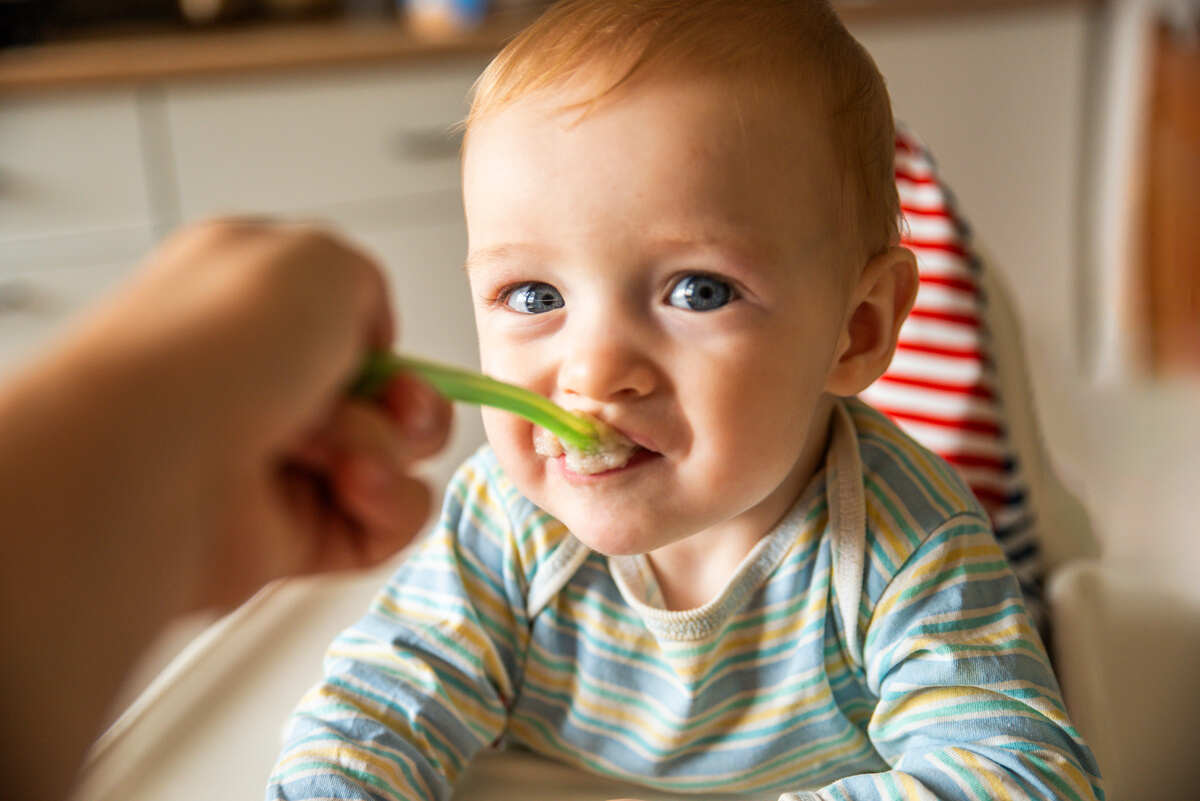 bambino che mangia sul seggiolone